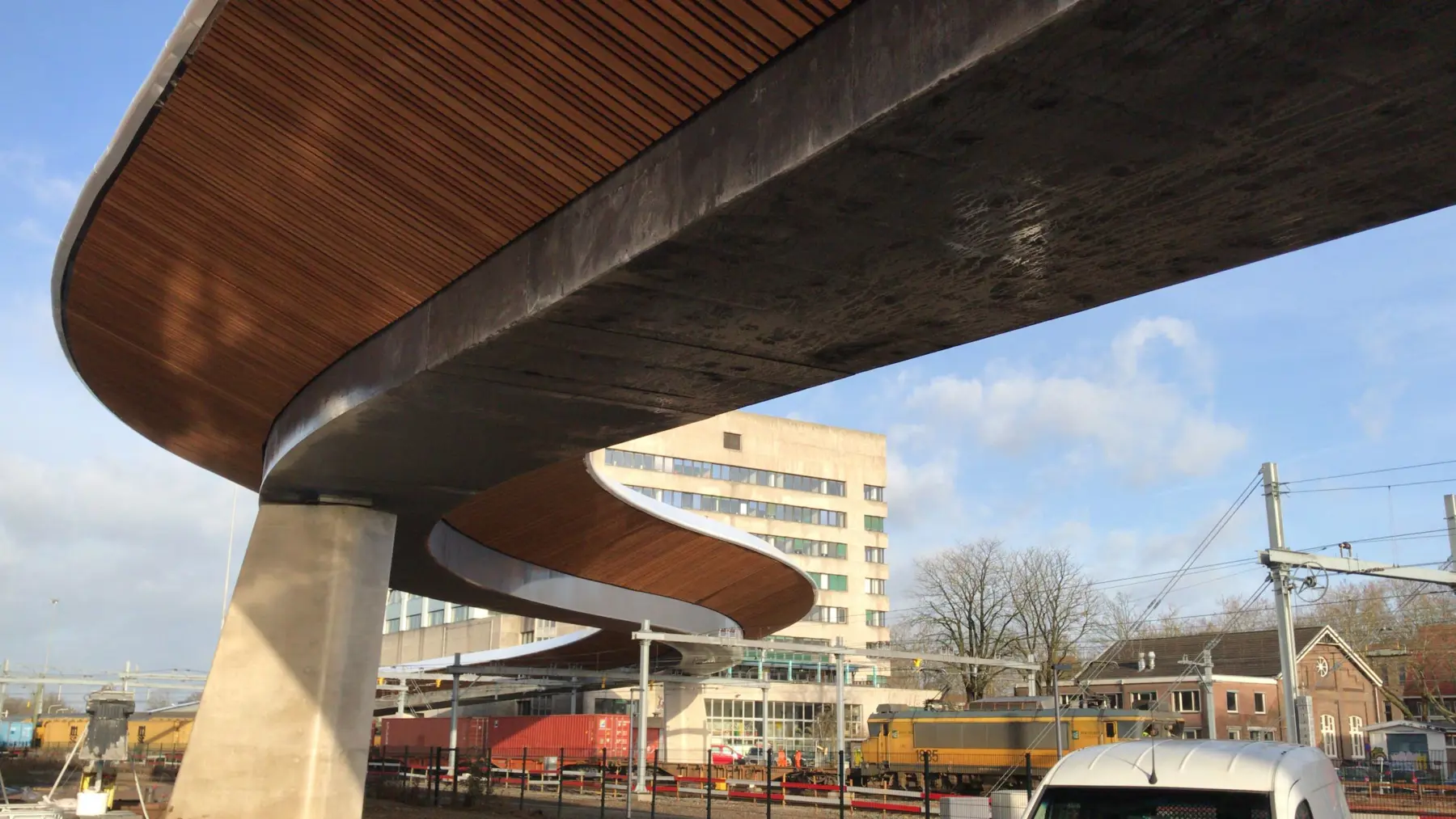 Busbrug heeft duidelijk S vorm en is met hout bekleed.