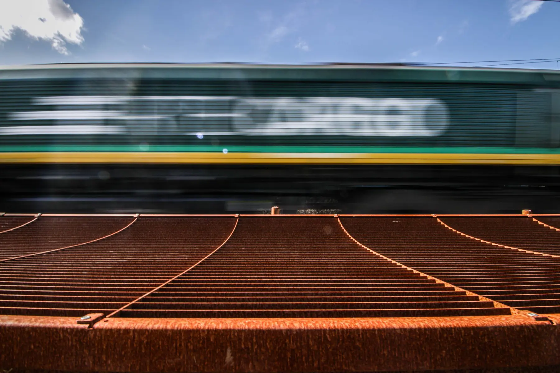 Een goederentrein passeert het nieuwe geluidsscherm in Susteren