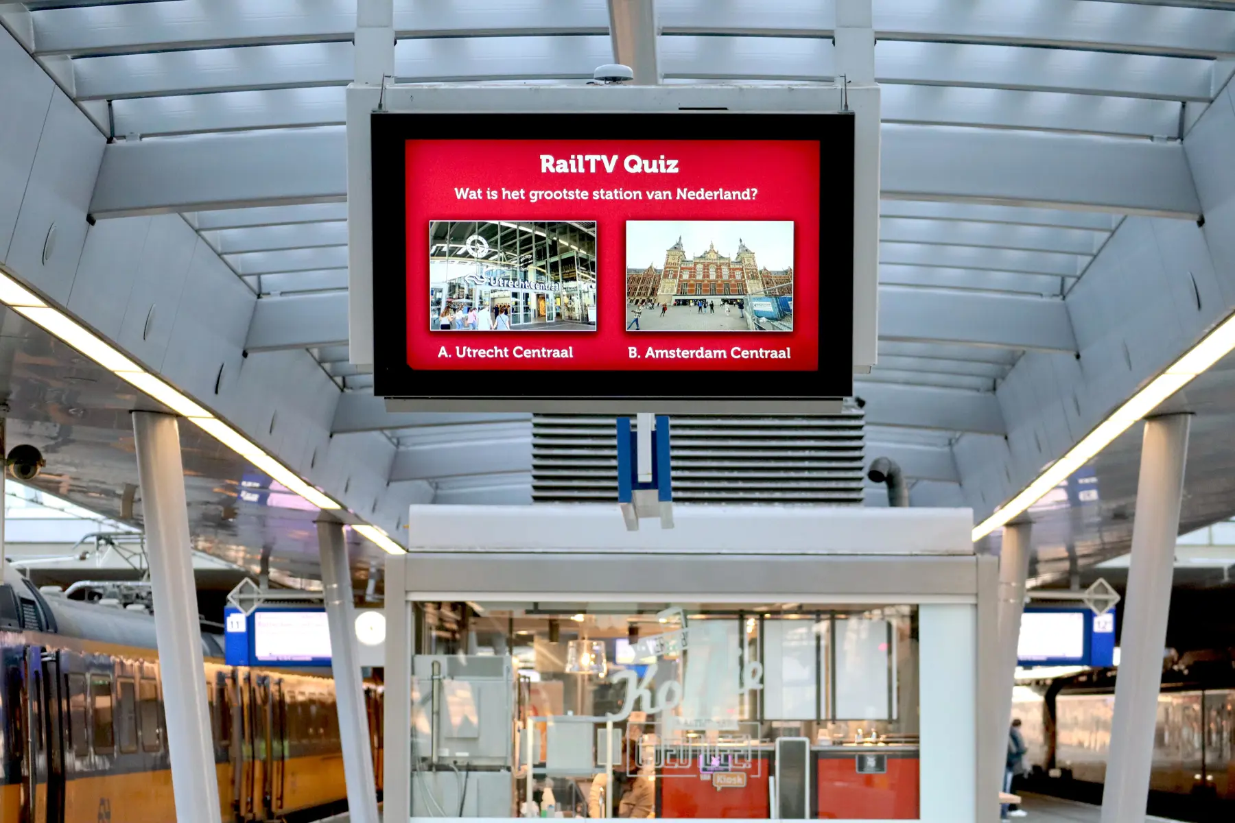 De schermen van RailTV hangen op perrons