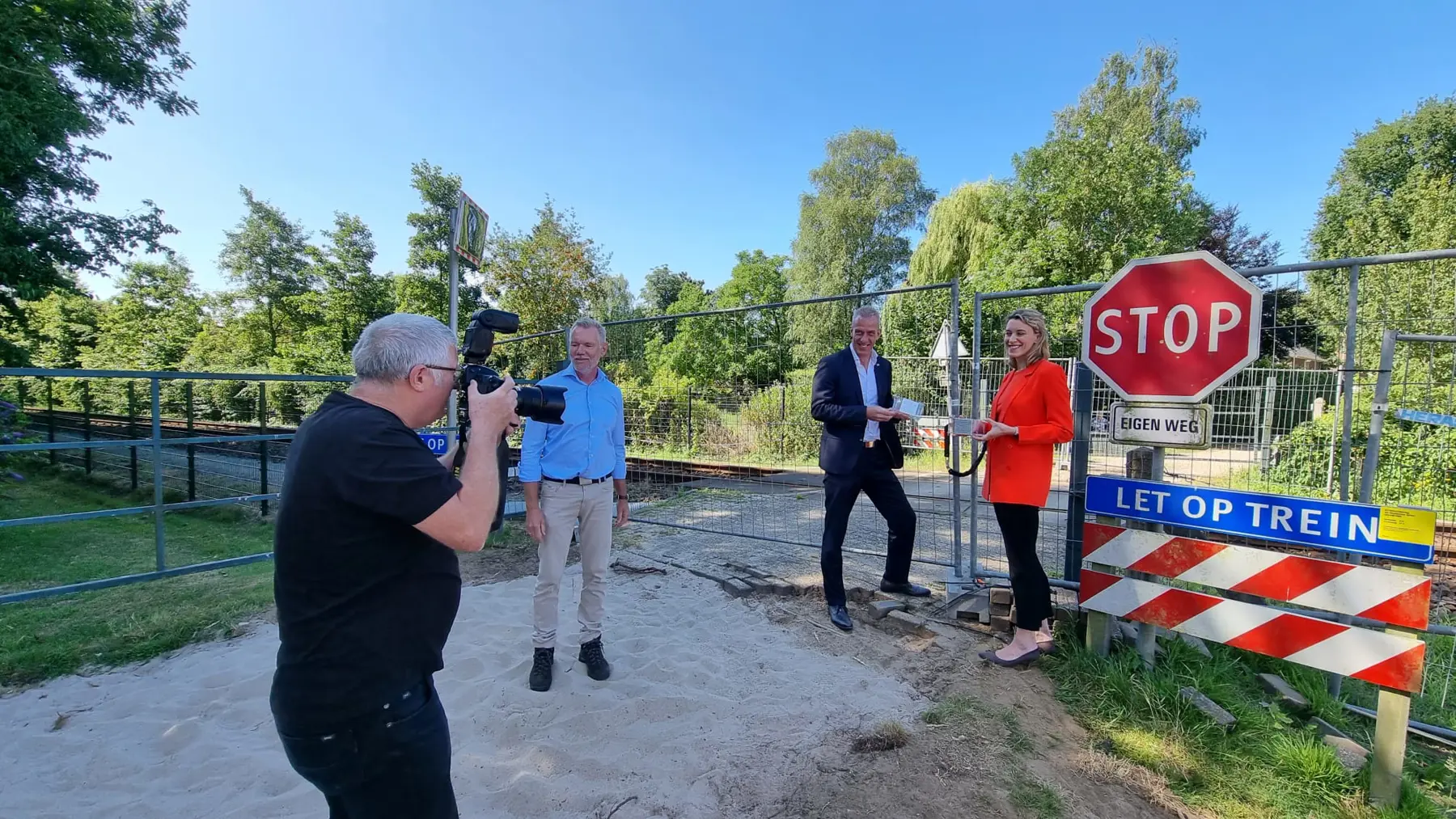 Regiodirecteur Danou Veenhof gaat op de foto bij de opgeheven overweg