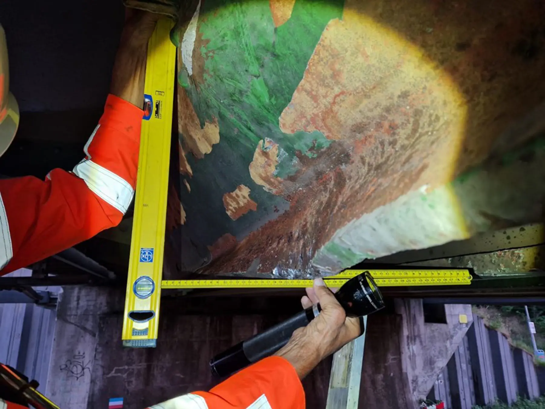 Experts meten de schade op aan de spoorbrug in Sittard