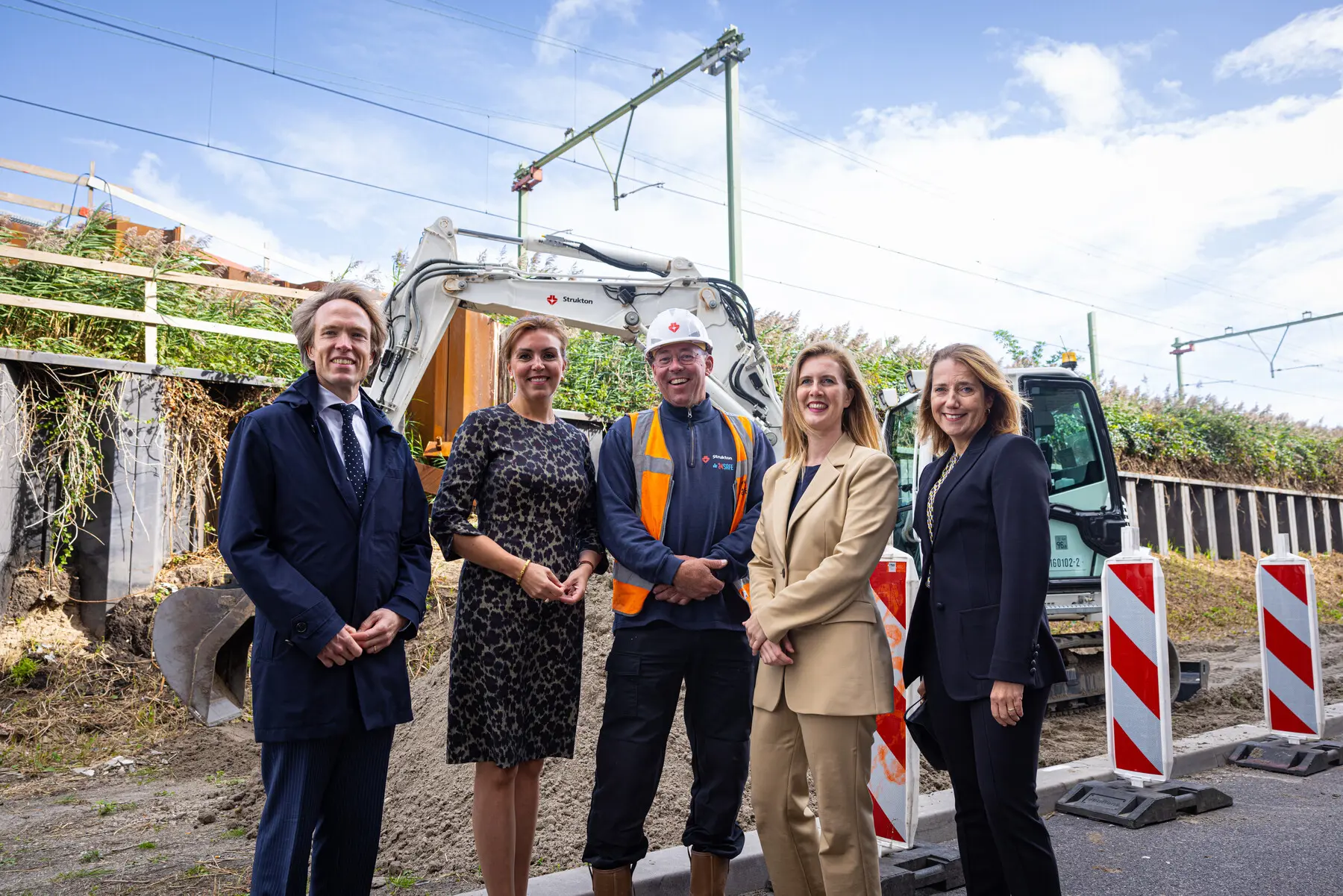 Tjalling Smit (NS), staatssecretaris Vivianne Heijnen, machinist Marc Vlaar van Strukton, wethouder Melanie van der Horst en Mirjam van Velthuizen (ProRail) op de Dijksgracht