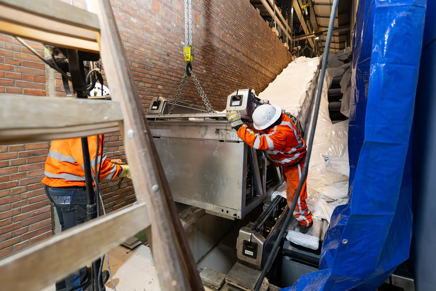 Het monumentale karakter van het IJ-gebouw wordt versterkt door de monumentale bakstenen gevel door te trekken langs de roltrappen.